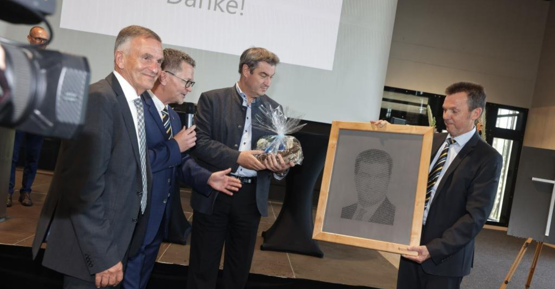 Als Geschenk bekam Markus Söder ein „durchlöchertes“ Porträt von stellvertretenden Schulleiter Georg Bachmeier (r.) überreicht. Das Bild wurde angefertigt von Glasern, Schreinern und Metallbauern der Berufsschule. „So werde ich normalerweise nur bei Markus Lanz gelöchert“, sagte der Ministerpräsident, hier am Foto mit Walter Taubeneder (v.l.) und Schulleiter Albert Heider.