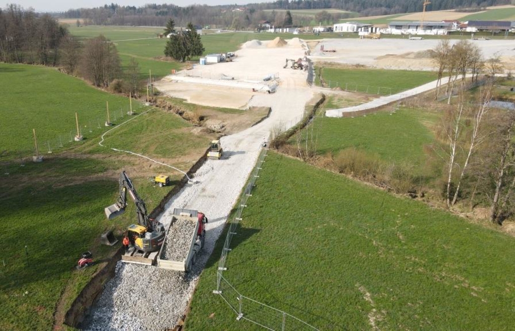 Zu den vorbereitenden Arbeiten gehört der Bau einer Baustraße (im Vordergrund). Über diese kann auch das 120 Tonnen schwere Großbohrpfahlgerät bis zur Ohe transportiert werden. Die Baustraße dient später als Betriebsstraße unter der Brücke, die Zufahrt ist rechts im Bild bereits zu erkennen. Am Ende der Schotterschicht in der Bildmitte entsteht ein Widerlager der zukünftigen Talbrücke. - Foto: Staatliches Bauamt Passau / Süß