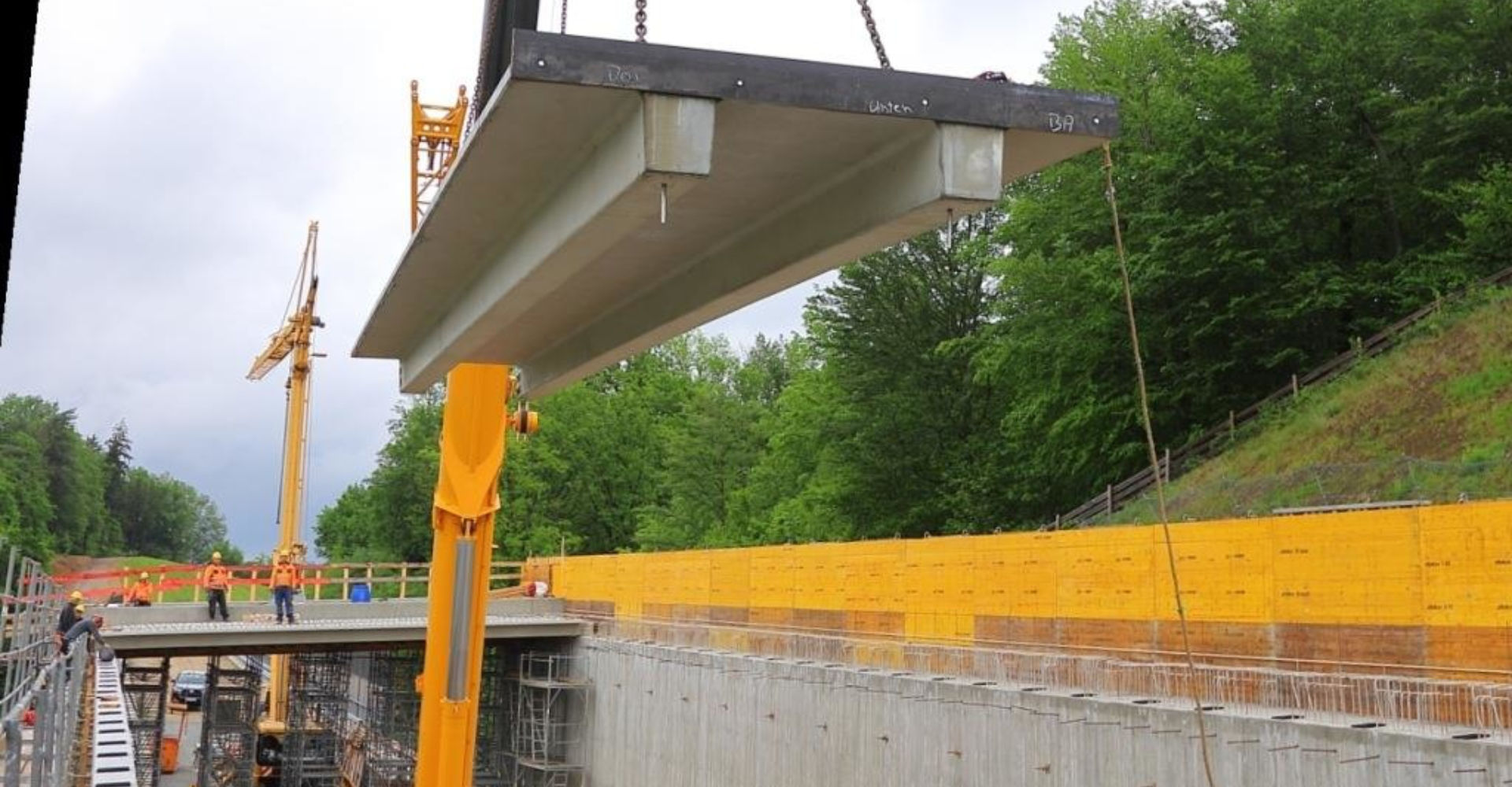 Mit dem Autokran werden die tonnenschweren Trägerplatten eingehoben und in Zentimeterarbeit an Ort und Stelle eingebaut. Mit dem Autokran werden die tonnenschweren Trägerplatten eingehoben und in Zentimeterarbeit an Ort und Stelle eingebaut.